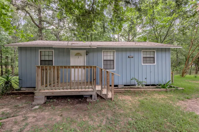 a view of a house with a yard and wooden fence