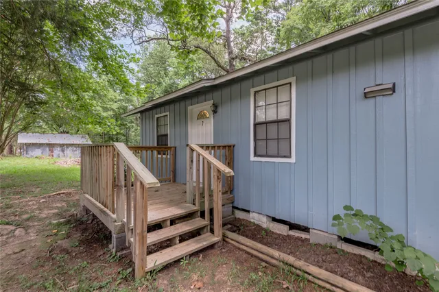 a view of backyard with deck and outdoor seating