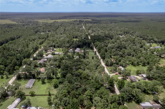 an aerial view of residential houses with outdoor space and trees