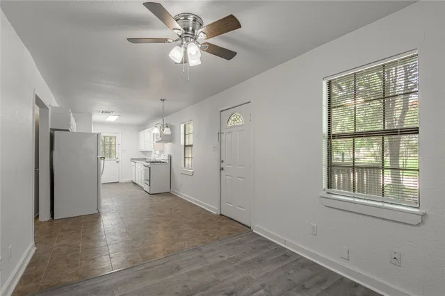 a view of a kitchen with a stove cabinets a ceiling fan and wooden floor