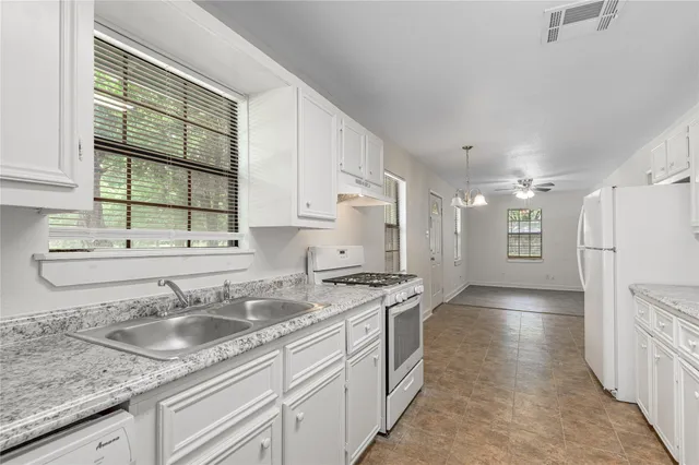 a kitchen with stainless steel appliances granite countertop a sink stove and cabinets