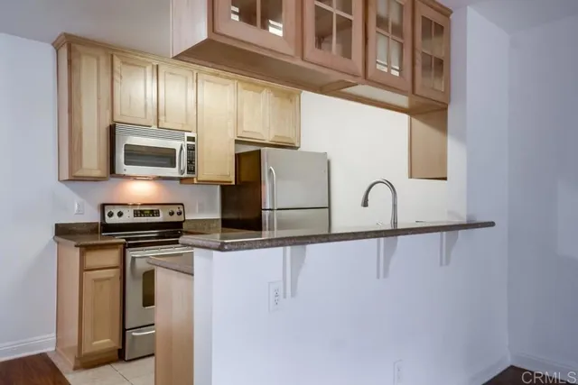 a kitchen with stainless steel appliances granite countertop a refrigerator a stove and a sink