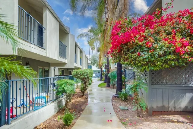 a view of a house with a small yard and flower plants