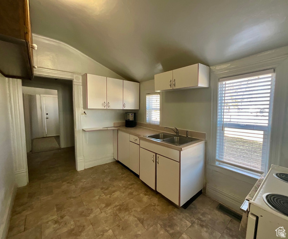 495 North Main Street Beaver, UT 84713 - Photo 8 of 18 Kitchen featuring lofted ceiling, white cabinets, light countertops, electric range, and stone finish flooring