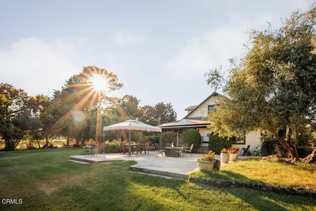 a view of a patio with table and chairs under an umbrella