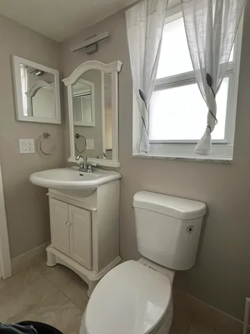 a bathroom with a toilet sink and mirror