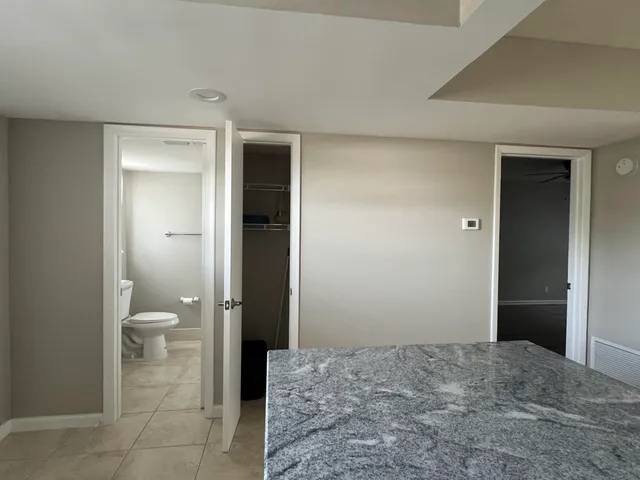 a bathroom with a granite countertop toilet and a shower