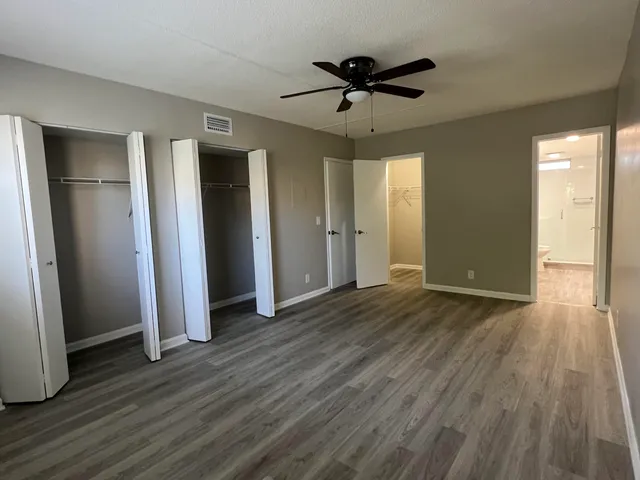 a view of empty room with wooden floor and window