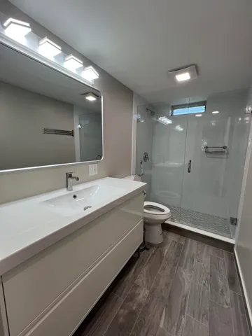 a bathroom with a double vanity sink toilet and shower