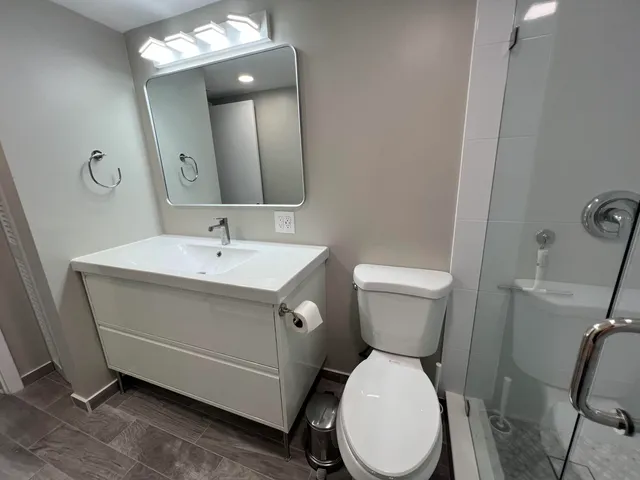 a bathroom with a sink mirror and toilet