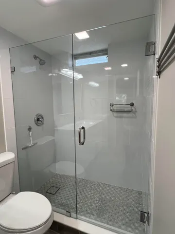 a bathroom with a toilet and a shower