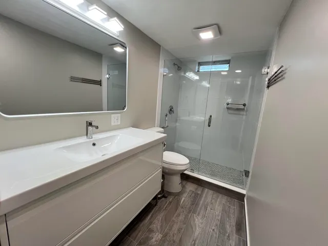 a bathroom with a double vanity sink toilet and shower