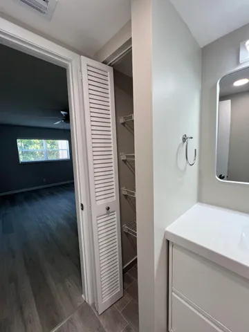 a view of bathroom with a sink mirror and window