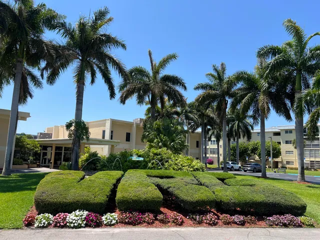 front view of a house with a garden and palm trees