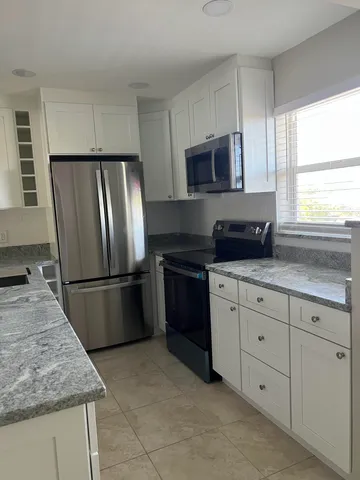 a kitchen with appliances a sink and a window