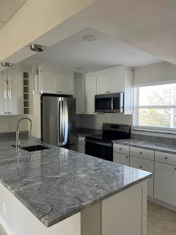 a kitchen with stainless steel appliances granite countertop a sink stove and refrigerator