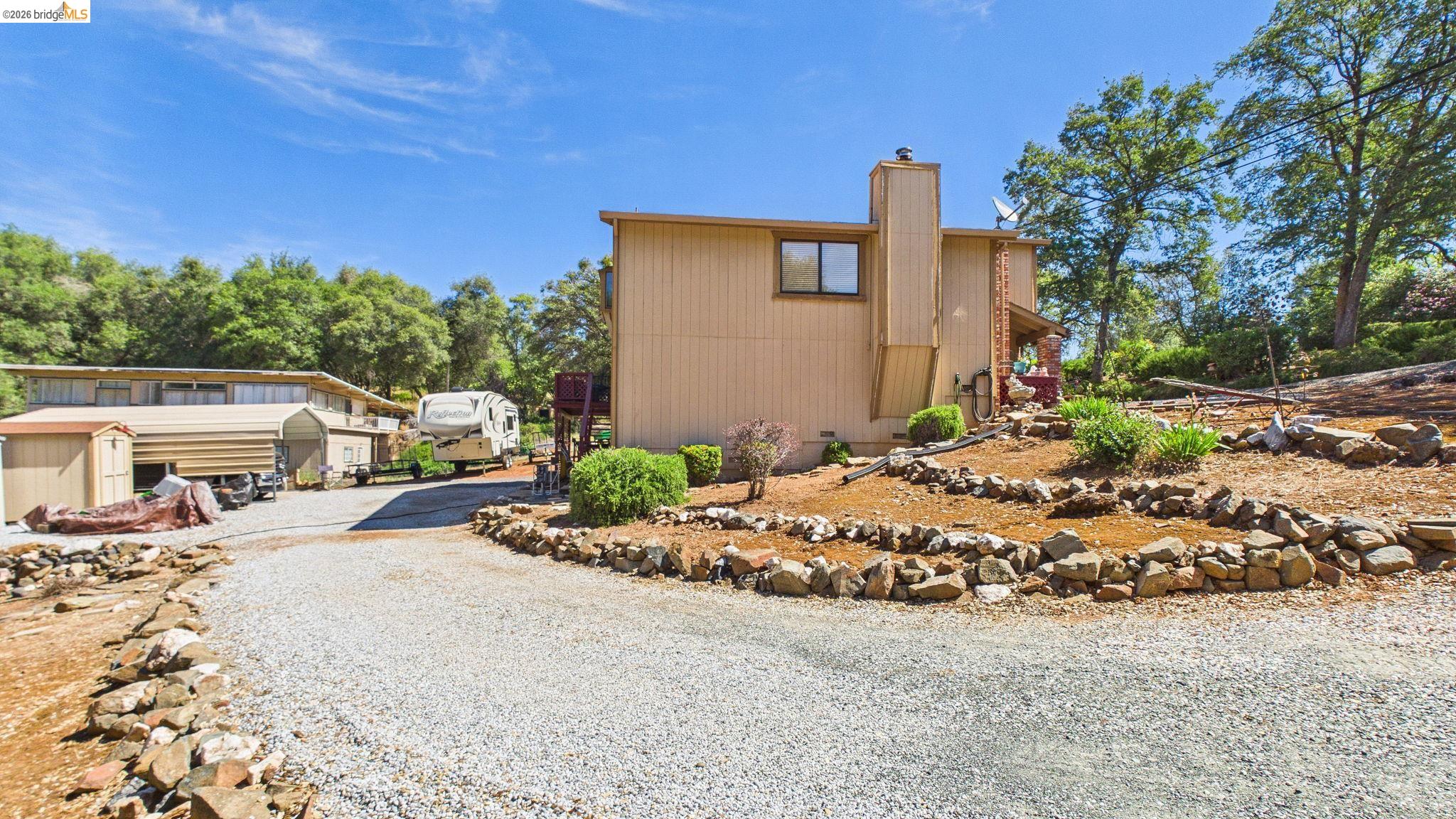 11858 Campo Seco Road Sonora, CA 95370 - Photo 7 of 45 Exterior property featuring tan siding and a gravel driveway