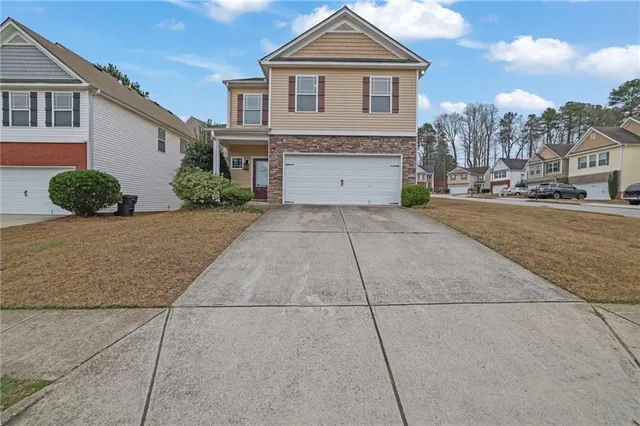 a front view of a house with a yard and garage