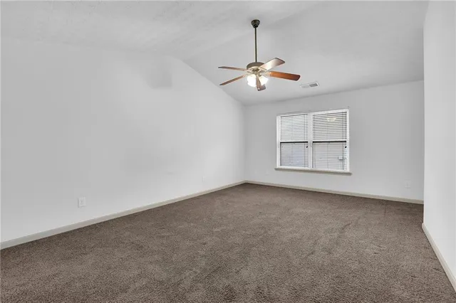 an empty room with windows and chandelier fan