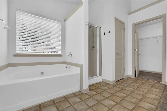 a view of an empty room with chandelier fan