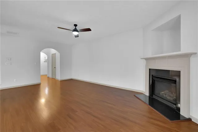 a view of empty room with wooden floor and fireplace