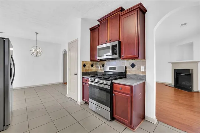 a kitchen with granite countertop a stove top oven and cabinets