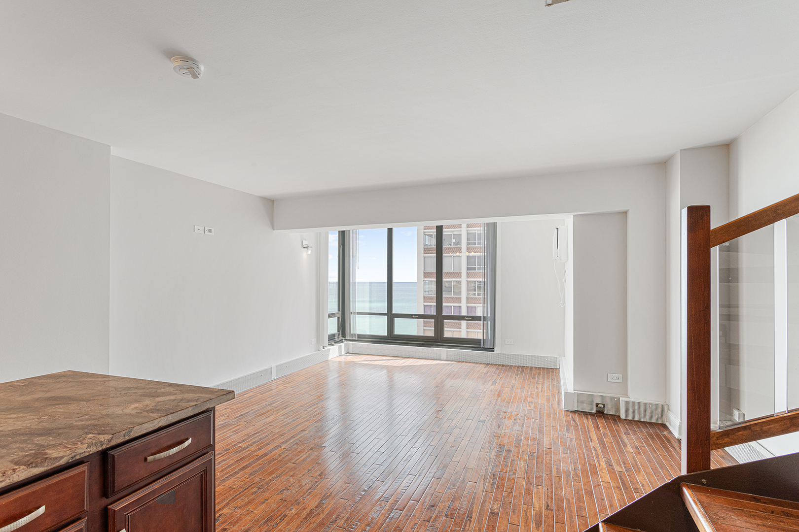 6166 North Sheridan Road, Unit 14F Chicago, IL 60660 - Photo 2 of 23 a view of an empty room with wooden floor and a window
