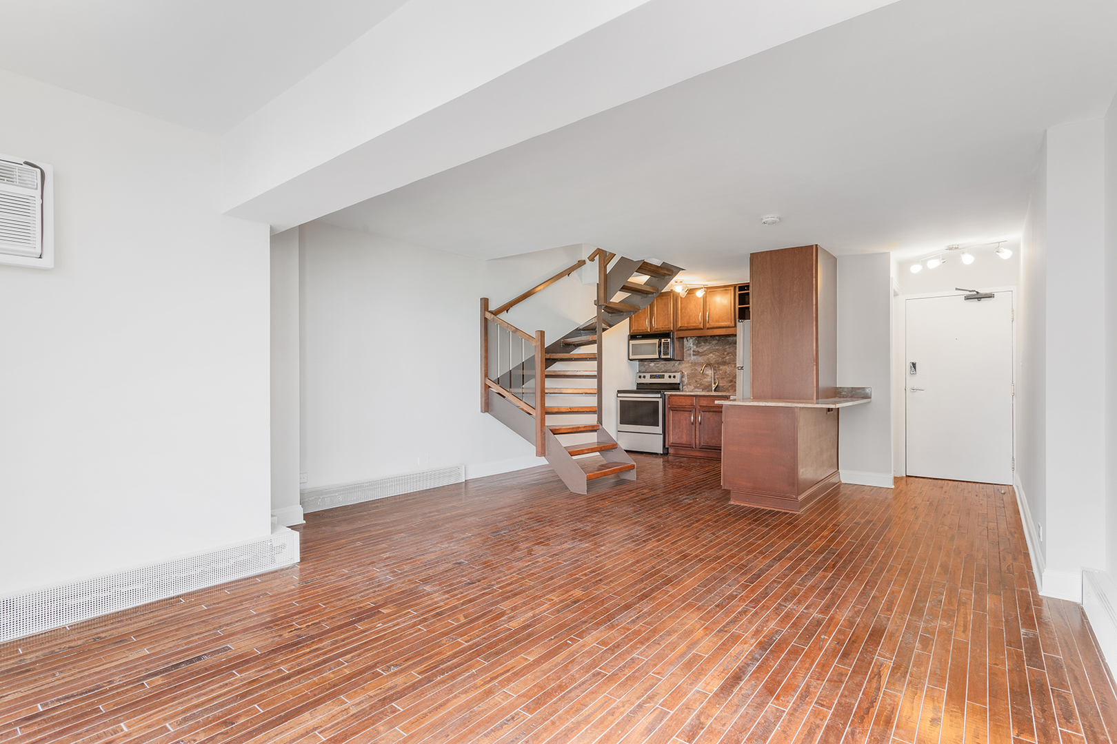 6166 North Sheridan Road, Unit 14F Chicago, IL 60660 - Photo 7 of 23 a view of a room with wooden floor and a refrigerator