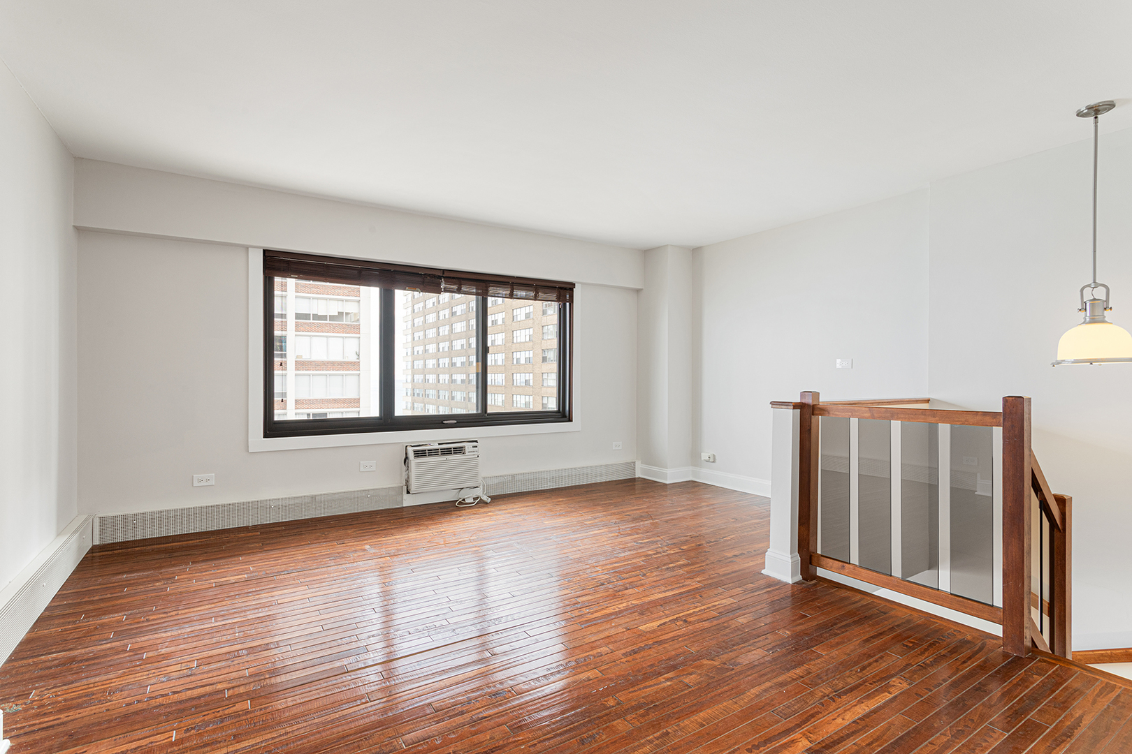 6166 North Sheridan Road, Unit 14F Chicago, IL 60660 - Photo 9 of 23 a view of an empty room with wooden floor and a window