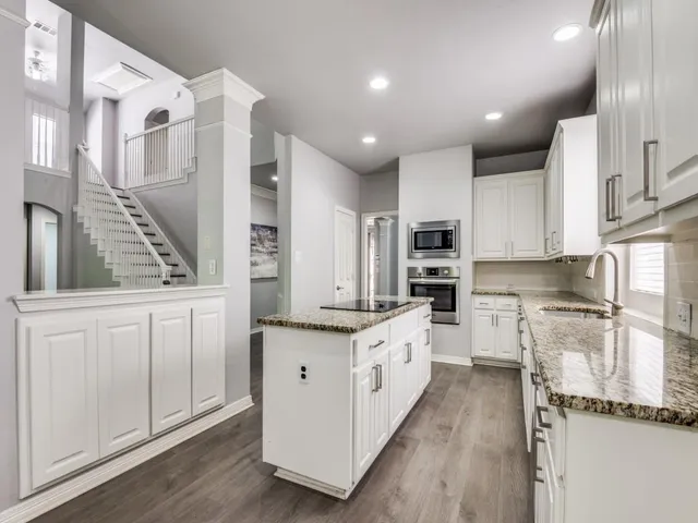 a kitchen with stainless steel appliances kitchen island granite countertop a stove and a sink