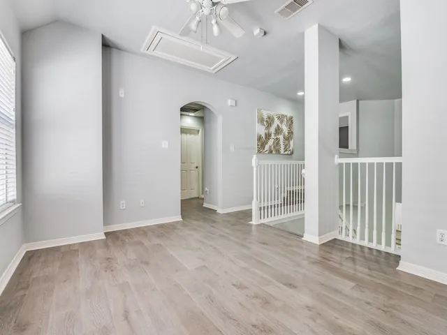 an empty room with wooden floor and a bathroom