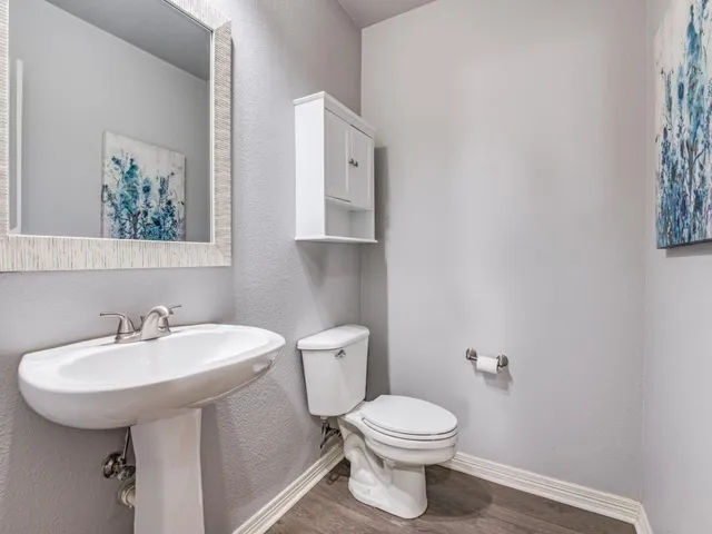 a bathroom with a toilet a sink and mirror