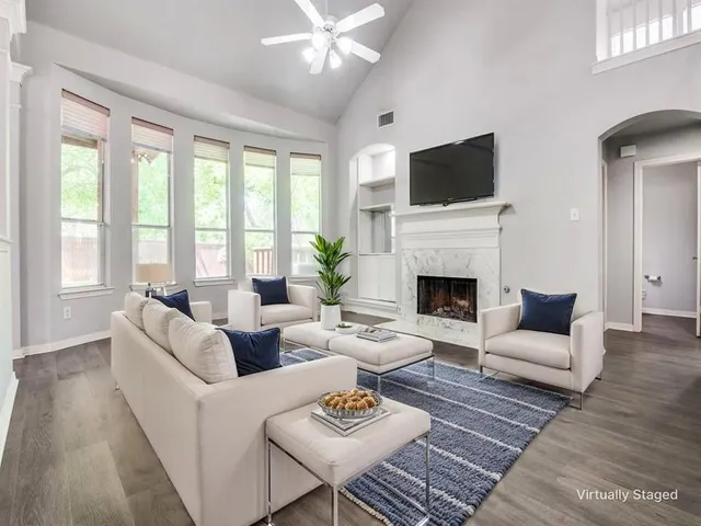 a living room with furniture a flat screen tv and a fireplace