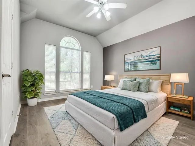a spacious bedroom with a large bed and a chandelier