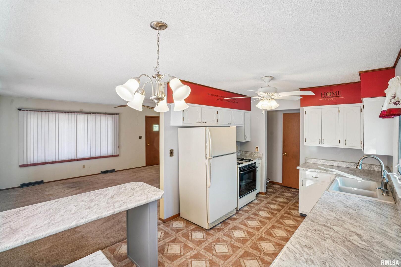 8101 8th Street West Rock Island, IL 61201 - Photo 8 of 25 a kitchen with stainless steel appliances granite countertop a sink a refrigerator and a stove