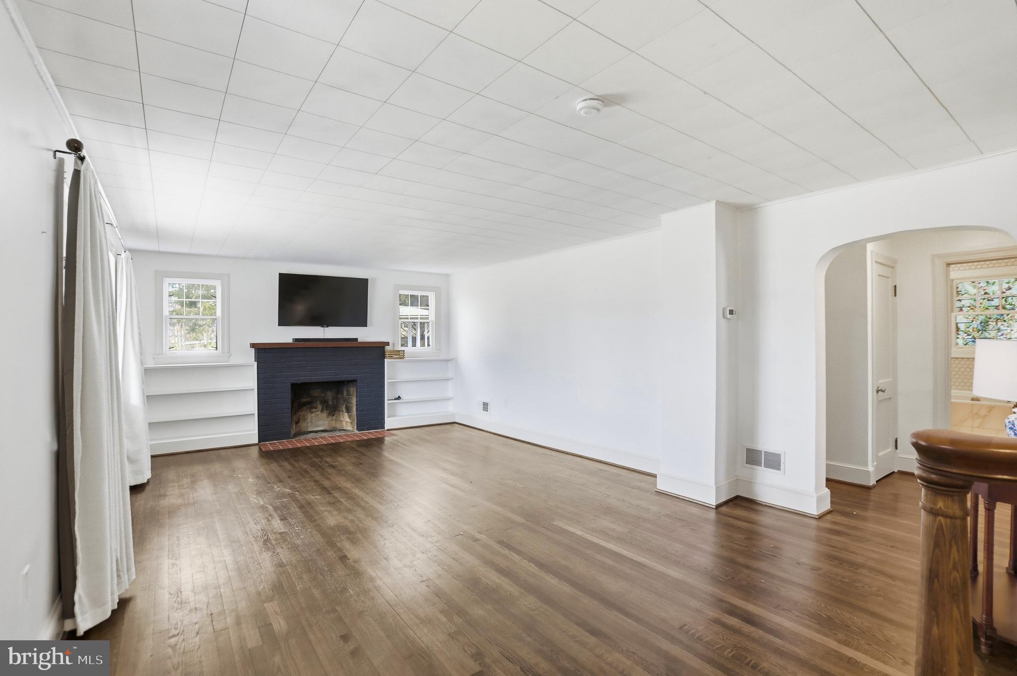 12242 Harpers Ferry Road Purcellville, VA 20132 - Photo 15 of 49 an empty room with wooden floor fireplace and windows