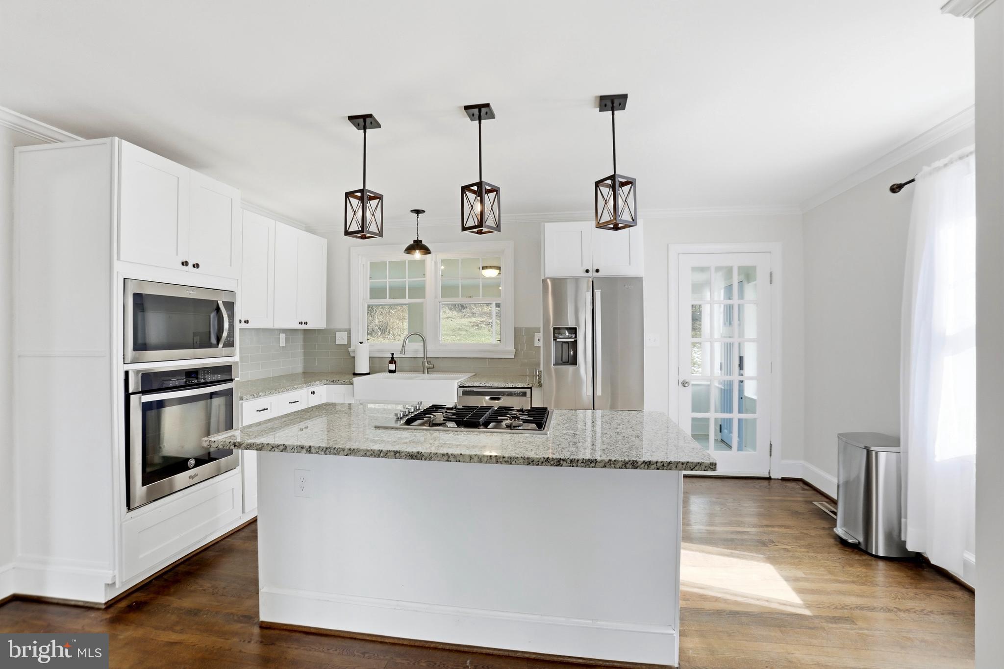 12242 Harpers Ferry Road Purcellville, VA 20132 - Photo 24 of 49 a kitchen with stainless steel appliances granite countertop a sink a stove a refrigerator cabinets and wooden floor
