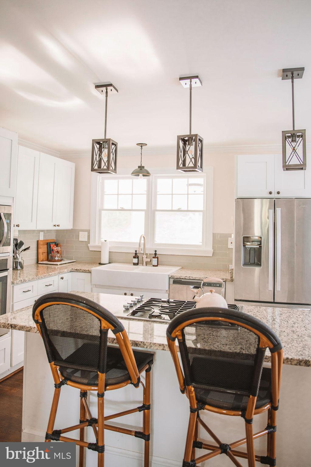 12242 Harpers Ferry Road Purcellville, VA 20132 - Photo 26 of 49 a kitchen with a table chairs a sink dishwasher window and cabinets