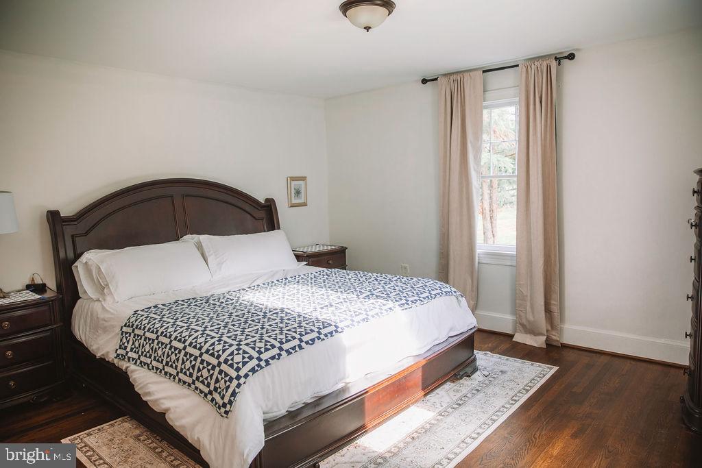 12242 Harpers Ferry Road Purcellville, VA 20132 - Photo 29 of 49 a bedroom with a bed and wooden floor