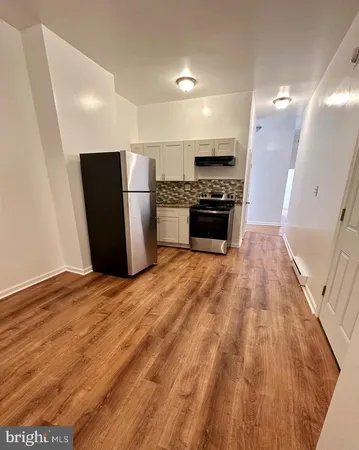 a kitchen with granite countertop a refrigerator and a stove top oven