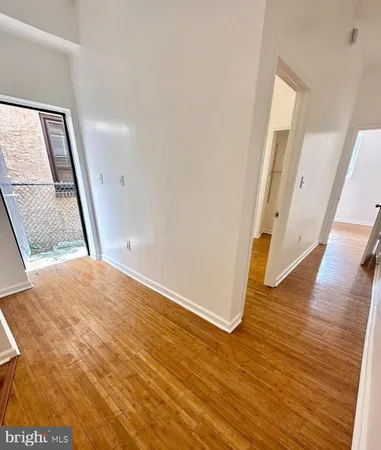 a view of a hallway to wooden floor with staircase