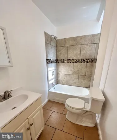 a bathroom with a bathtub shower sink mirror and toilet