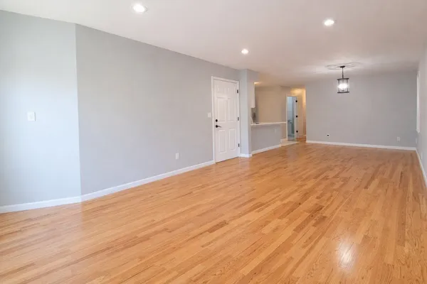 a view of empty room with wooden floor