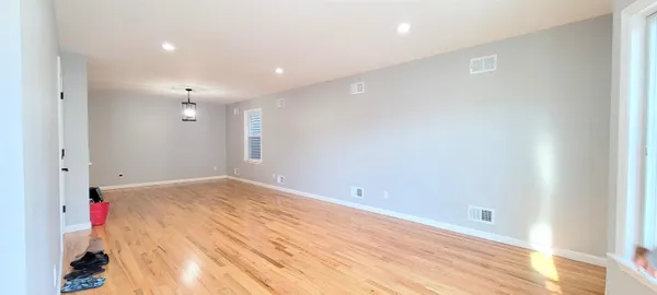 an empty room with wooden floor and entrance