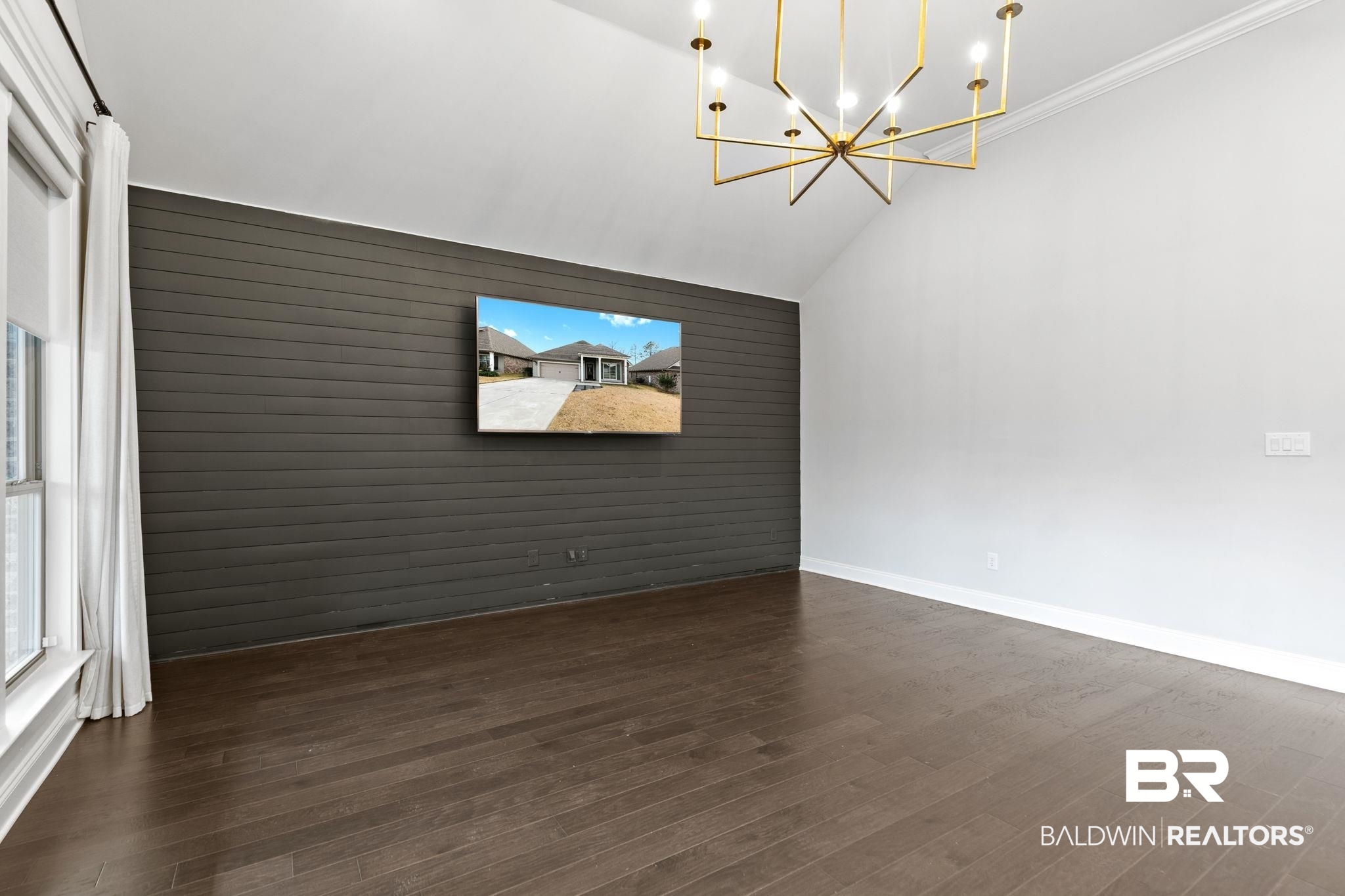 31654 Canopy Loop Daphne, AL 36527 - Photo 10 of 64 Spare room with an accent wall, suspended lighting, dark wood-style floors, wood walls, and lofted ceiling