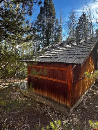 a view of a yard with plants and wooden fence