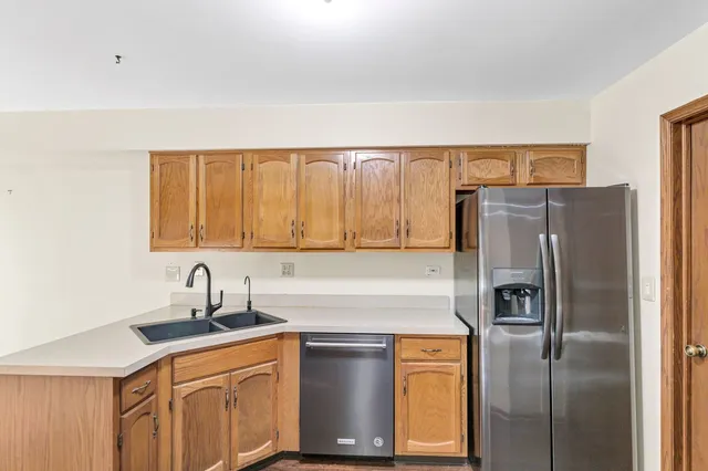 a kitchen with stainless steel appliances granite countertop a refrigerator a sink and dishwasher