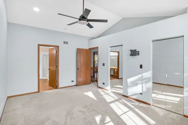a view of a livingroom with a chandelier fan and windows