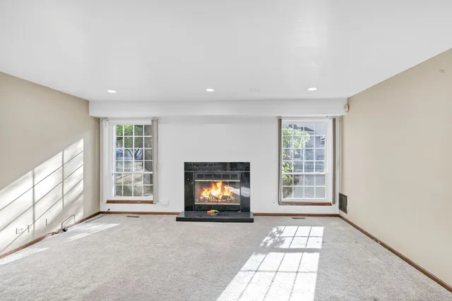 an empty room with windows fire place and windows