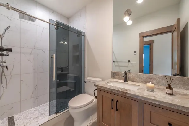 a bathroom with a granite countertop sink toilet and shower